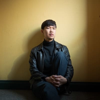 Qyunh Tran sitter i en trappuppgång.