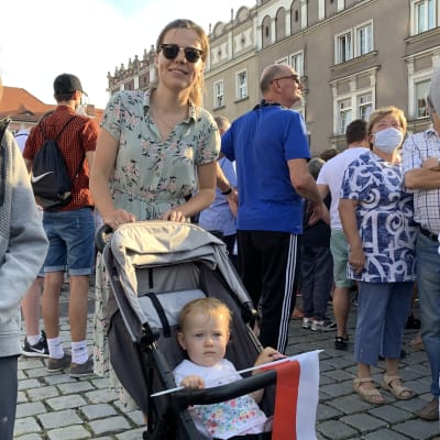 Justyna tillsammans med sin lilla dotter som sitter i barnvagn.