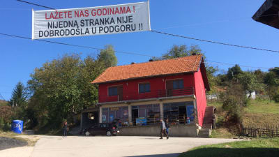By i Bosnien med skylt över att politiker är förbjudna i byn. 