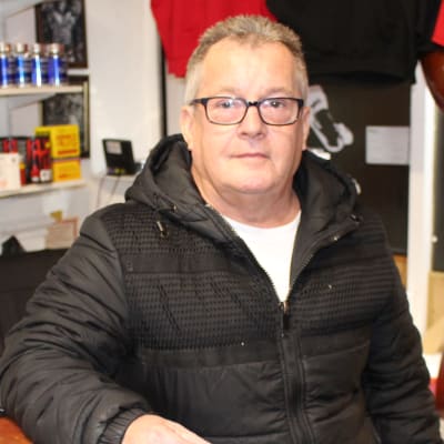 Företagaren Roy Crompton fotograferade i sin affär i Wigan. Crompton är en man i medelådern med kort grått hår. 