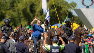 Brasiliens president Jair Bolsonaro till häst med anhängare i Brasilia 31.5.2020. 