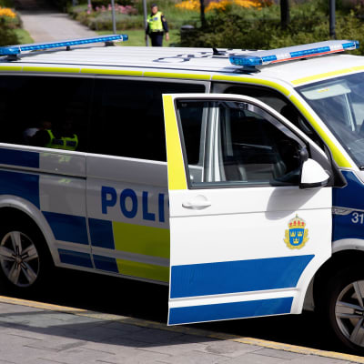 En svensk polisbil står vid en gata.