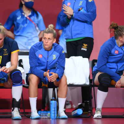 Tre svenska spelare sitter på en bänk och deppar.