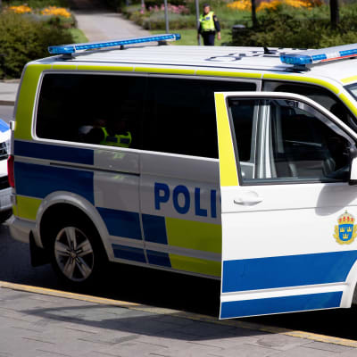 En svensk polisbil står vid en gata.