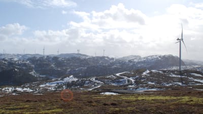 Tjugotals vindmöllor i fjällandskap.