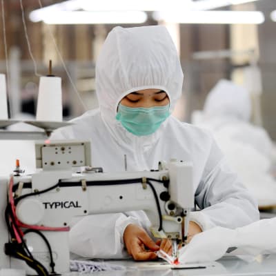 Efterfrågan på skyddsutrustning är enorm i Kina just nu. På en fabrik i Ningjin, söder om Peking, bar arbetarna själva skyddsdräkter medan de tillverkade dem. 