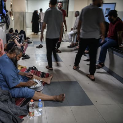 En man sitter på golvet på ett sjukhus i Gaza