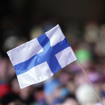 En person viftar med Finlands flagga.