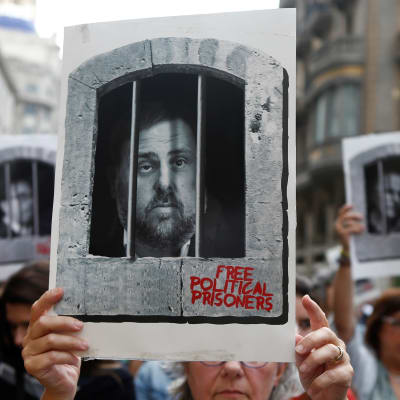 En demonstrant håller upp en skylt som föreställer den tidigare vice regionpresidenten i Katalonien Oriol Junqueras som dömdes till 13 års fängelse.