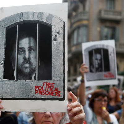 En demonstrant håller upp en skylt som föreställer den tidigare vice regionpresidenten i Katalonien Oriol Junqueras som dömdes till 13 års fängelse.