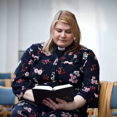 Salla Romo med en psalmbok i händerna i Noljakan kirkko i Joensuu.