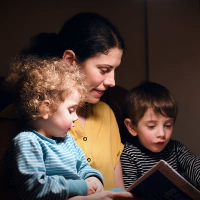 Marina Donner läser bok med barnen Kira och Viktor.