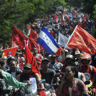 Demonstranter går längs med en av huvudgatorna i Tegucigalpa.
