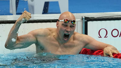Matti Mattsson jublar och håller upp händerna i vattnet för att fira brons i OS.