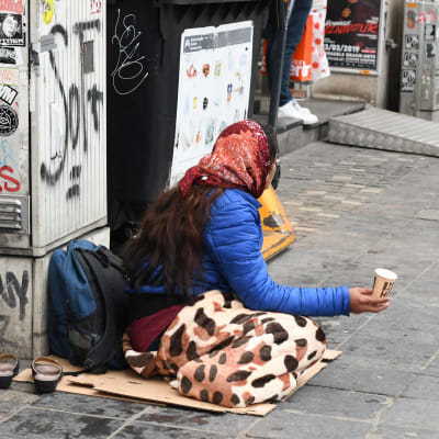 Kvinna tigger på gata.