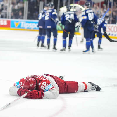 Besviken dansk spelare ligger på isen.
