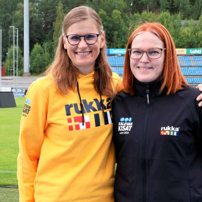 Kalevan kisoissa lähettäjinä toimivat Katja Hautaniemi ja Kirsi Kemppainen seisovat stadionilla Lahdessa.