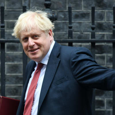 Boris Johnson heilauttaa kättään.