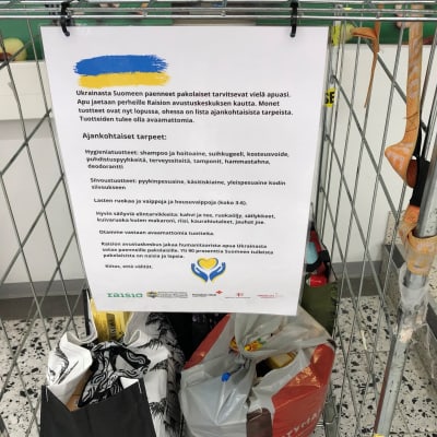 Ukrainalaisille kerättyjä avustustarvikkeita rullakossa marketin käytävällä.