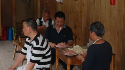 På en servering i en småstad röker en man medan han tillreder kinesiska köttpiroger. Ingen skulle komma att tänka på att protestera.