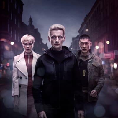 De tre huvudpersonerna i Bedrägeriet, säsong 3, står på en gata i en mörk stad.