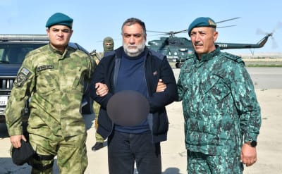 Ruben Vardanyan, en före detta separatistchef i Nagorno-Karabach, fängslad av två azeriska säkerhetstjänstemän