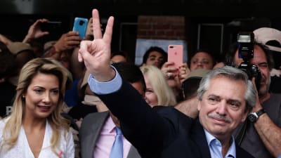 Alberto Fernández, från den vänsterperonistiska alliansen Frente de Toros, gjorde segertecknet redan utanför sin vallokal i Buenos Aires på söndagen. 