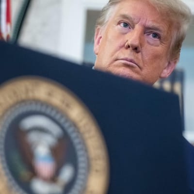 USA:s president Donald Trumps ansikte syns över kanten på ett talarpodium.