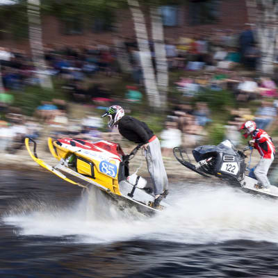 Vesikrossissa kilpailijat ajavat moottorikelkoilla vettä pitkin.