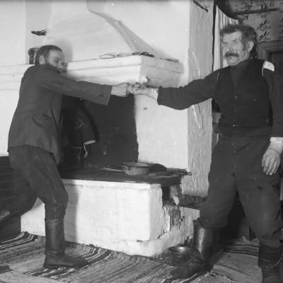 Två män leker leken "dra fingerkrok". Bilden är tagen i Strömfors, Kungsböle 1936.