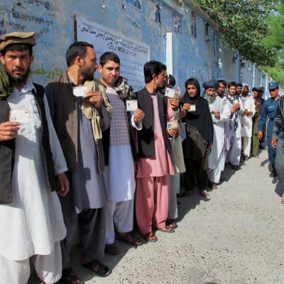 Afghaner köar utanför en vallokal i Helmanprovinsen 14.6.2014