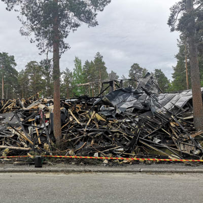 bild på hög med bränt trä och saker som brunnit upp i en brand i en radhuslänga. 