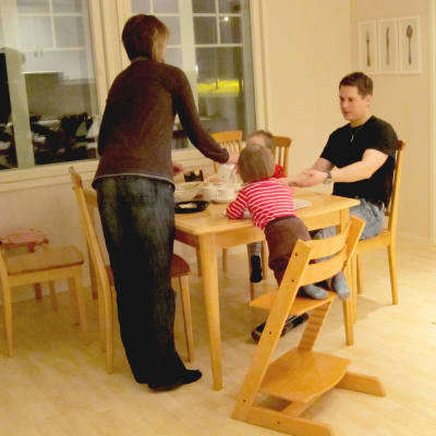 barn i matstol med förälder bredvid
