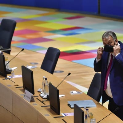Ungerns premiärminister Viktor Orban står bakom ett mötesbord