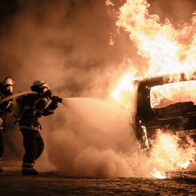Brandmän släcker en brinnande bil i Hamburg den 8 juli under demonstrationerna kring G20-mötet.