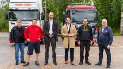 Sex män står ute framför två parkerade långtradare. Från vänster: Hasse Rajalin, Niklas Rajalin, Johan Kvarnström, Henrik Wickström,  Jani Nummelin och Stig-Henrik Sjöblom.k