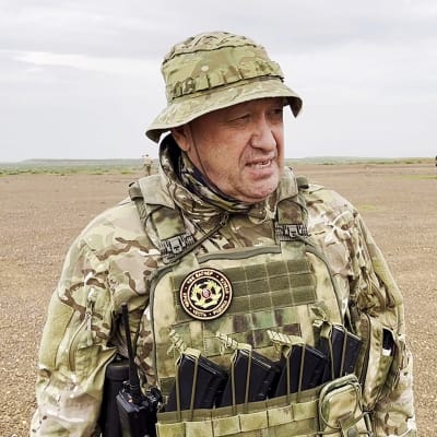 Jevgenij Prigozjin tittar åt sidan klädd i militärutrustning.