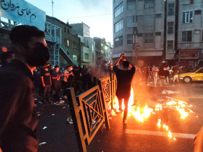 Demonstranter och eld på gata i Teheran.