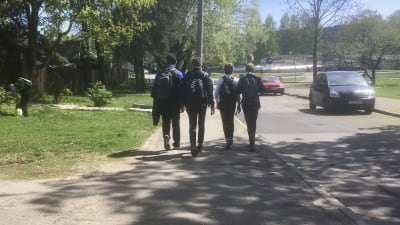 Fyra ryska skolungdomar går hem efter skolan, fotade bakifrån