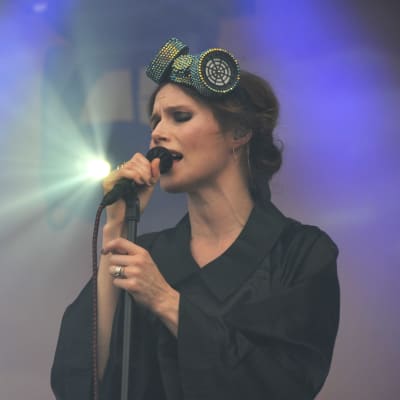 Sångaren Nina Persson uppträder på en lilafärgad scen på Rusrock.