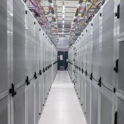 Datakeskuksen konesalissa pelkistä serverikaapeista muodostunut käytävä.