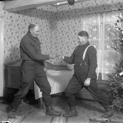 Två män leker leken "dra dosa", där man ska dra en snusdosa från den andras händer. Bilden är tagen 1937 i Korsnäs, Harrström.