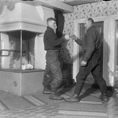 Två män leker "knokas", där man turvis slår på varandras knutna händer, allt hårdare. Den som tål mest vinner. Bilden är tagen 1937 i Korsnäs, Harrström.