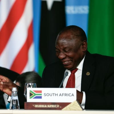Rysslands president Vladimir Putin och Sydafrikas president Ramaphosa skrattar tillsammans.