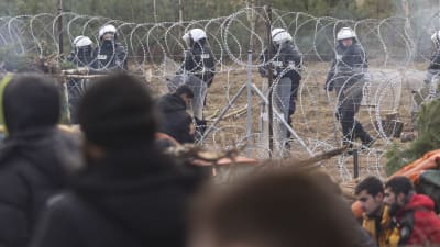 Polis vid gränsen mellan Polen och Belarus. I bild syns också migranter.