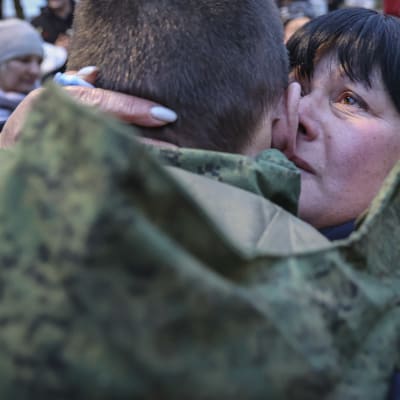 Venäläisen sotilaan äiti kyynelehtii ja syleilee poikaansa.