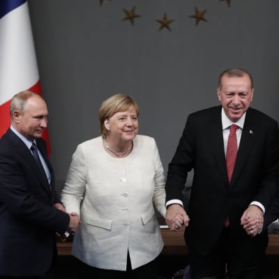 Rysslands president Vladimir Putin, Tysklands förbundskansler Angela Merkel, Turkiets president Recep Tayyip Erdoğan och Frankrikes president Emmanuel Macron håller varandras händer efter avslutat Syrienmöte i Istanbul. 