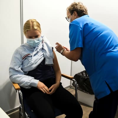 Sairaanhoitaja Airi Valkonen antamassa koronavirusrokotetta helsinkiläiselle 15-vuotiaalle Rorja Räsäselle