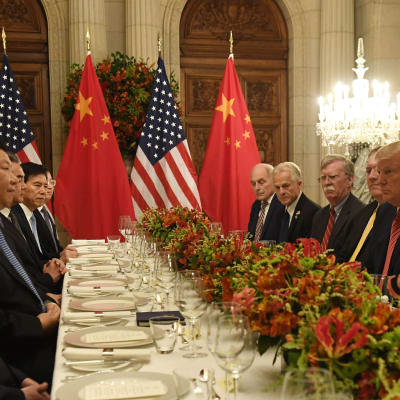 Amerikansk och kinesisk delegation vid dukat bord i Buenos Aires. Trump tittar stint på sin kinesiska kollega. 