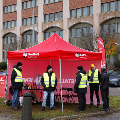Lakkovahdit seisovat rakennuksen edessä.